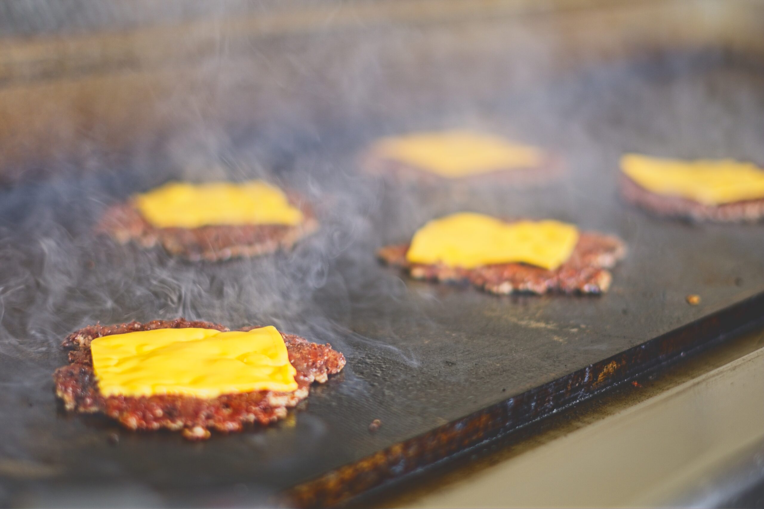 5 smash burgers on a grill at an event in Somerset